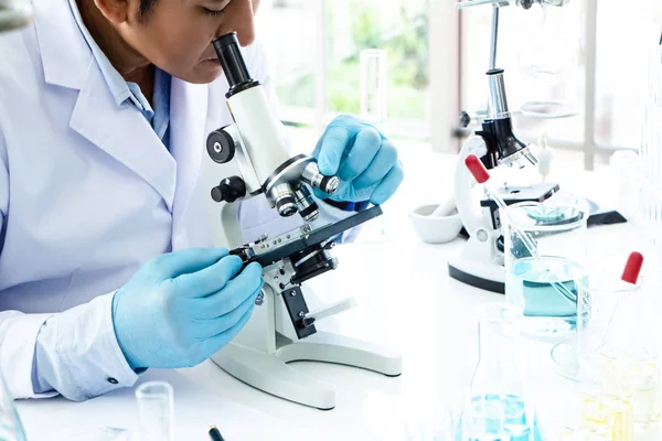 The scientist using Microscope to see objects that are too small to be seen by the naked eye,research for scient project,working at Laboratory