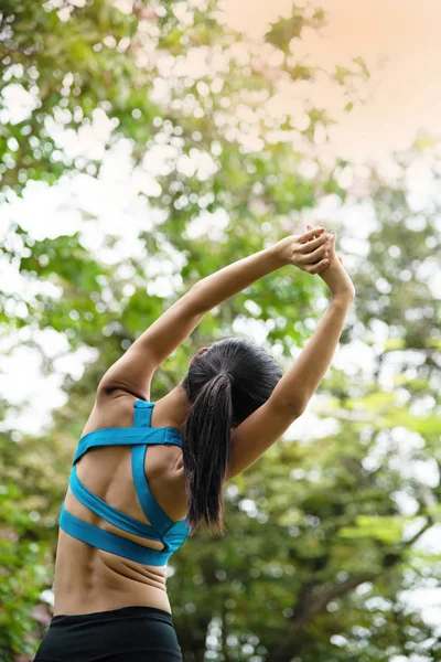 Kvinna Bär Träningsdräkt Stretching Rygg Och Kropp Genom Att Höja — Stockfoto