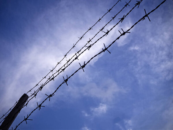 The silhouette barbwire stacked in line,on sky background,abstract and art tone