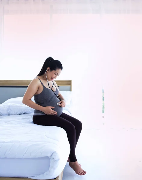 Pregnant Woman Sitting Bed Put Stethoscope Touch Her Belly Listening — ストック写真