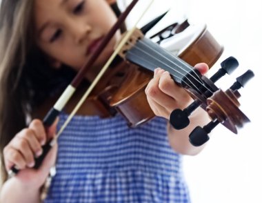 İnsan elinin seçici odak noktasında, keman teline basarak, akustik enstrüman nasıl çalınır, bulanık ışık nasıl çalınır göster.