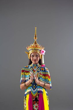 Renkli boncuklardan yapılmış Tayland halk dansları kostümü giyen güzel kadın, kafasındaki başlık, pratik yapmaya ve önsezilerini göstermeye hazırlanıyor.