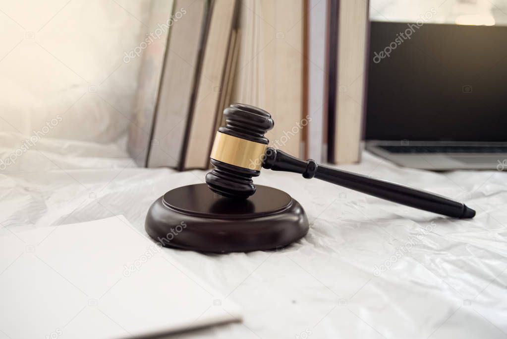 The wooden judge gavel and soundboard put beside book stacked,on background,burry light around