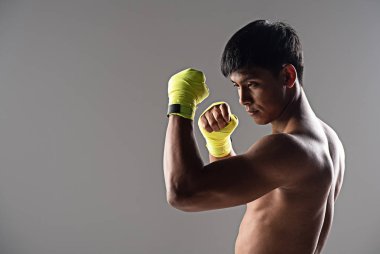 Sarı eldiven giyen yakışıklı adam, yumruk atmaya, egzersiz yapmaya ve kas yapmaya hazır ol.