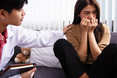 Doktorun yanında oturan stresli kadın, panik ve mutsuz duygularla, Pshchiartist cesaretlendirmek için elini omzuna koydu.