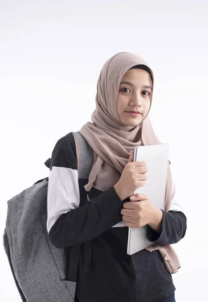 美しいイスラム教徒の女性が手にノートパソコンを持って バックパック 背景に立って 学校に行く準備をする — ストック写真