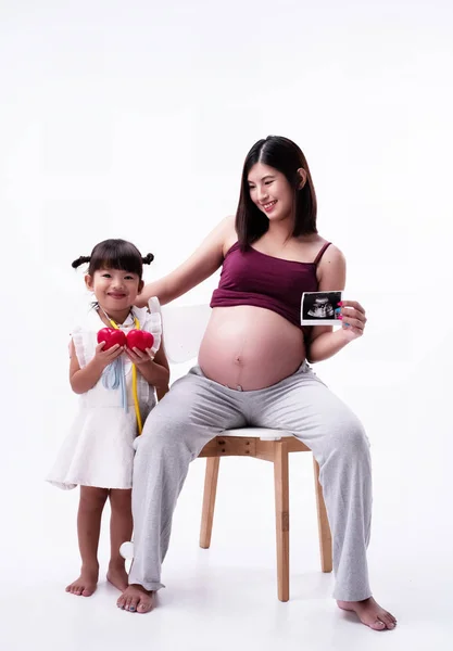 左の手で超音波シートを保持し 笑顔と幸せな気持ちで 木製の椅子に座っている妊婦 — ストック写真