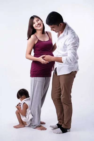 夫のそばに立っている妊婦さん 左側の1階に座っている娘さん 幸せな家族 愛とケア感 — ストック写真