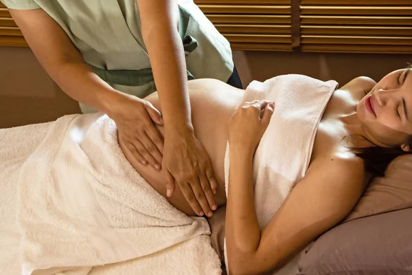 Spa terapisindeki tedavi ve rahatlama programı için hamile kadına masaj yapan terapist.