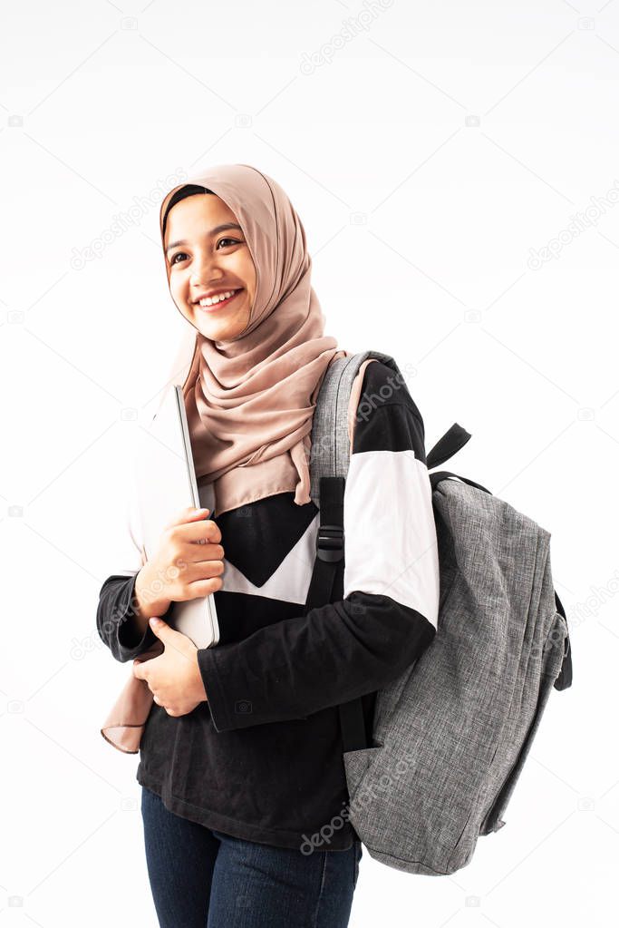 The beautiful muslim woman hugging laptop in her arm,with smile and happy feeling,prepare for go to study