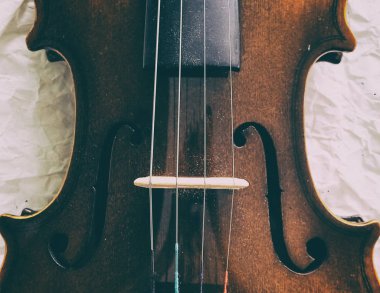 Keman arka planının soyut sanat tasarımı yarım ön tarafta, küçük toz ile, akustik enstrüman, klasik ve sanat tonu, etrafında bulanık ışık göbek göstermektedir