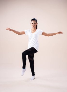 Zumba dansı yapan genç kadın, ellerini kaldır ve parmak uçlarını havaya kaldır, egzersiz için temel düzeni göster,