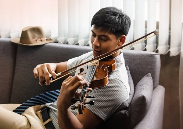 Der Gutaussehende Mann Sitzt Auf Dem Sofa Spielt Geige Mit — Stockfoto