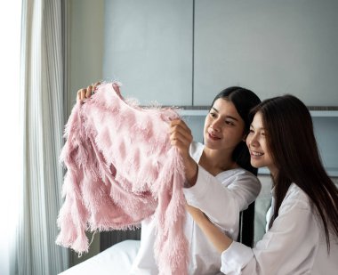 Giysileri birlikte seçen iki güzel bayan, mutlu bir duygu ve oda arkadaşı ile iyi bir dostluk.