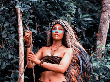 Güzel bayan boyalı yüz ve vücut kahverengi ve mavi renkli, elini kaldır boynuna dokun, modelin portresi etrafında bulanık ışık