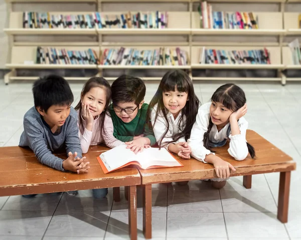 Beş Küçük Çocuk Ahşap Masanın Yanında Oturuyor Kitap Okuyor Konuşuyorlar — Stok fotoğraf
