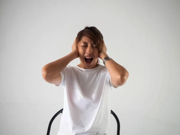 Kobieta Nosząca Aparat Siedząca Krześle Podnosząca Rękę Zamknęła Ucho Krzyczała — Zdjęcie stockowe