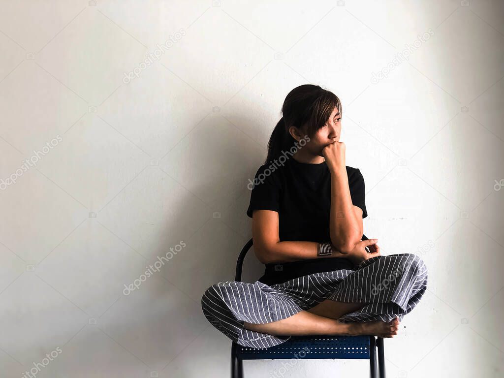 Stressed woman sitting on chair, looking something  with upset and unhappy feeling,depressive disorder syndrome,serious emotion,