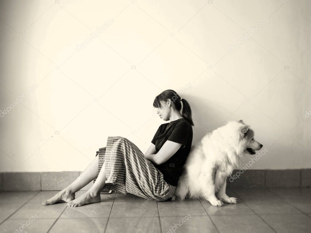 Stressed woman sitting by lean against her dog on ground floor,with ,unhappy feeling,tried and boring,upset emotion.The depressive disorder syndrome.vintage tone