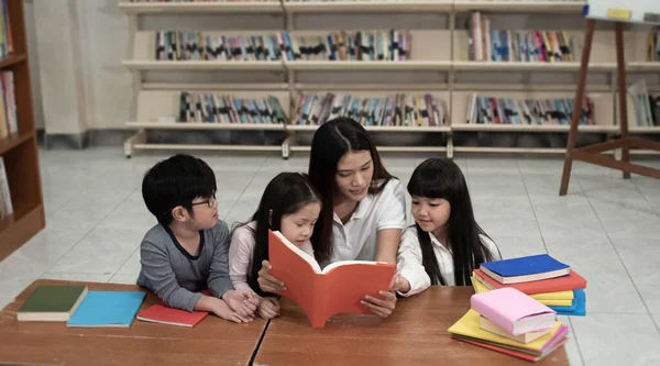 Gyönyörű Hölgy Olvasás Könyv Három Gyermek Érdeklődés Iskolában — Stock Fotó