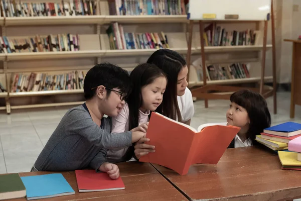 Három Gyerek Egy Gyönyörű Hölgy Együtt Olvas Könyvet Boldog Érzéssel — Stock Fotó