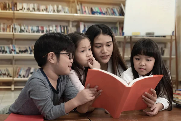 Mooie Dame Lezen Boek Met Drie Kinderen Met Een Gelukkig — Stockfoto