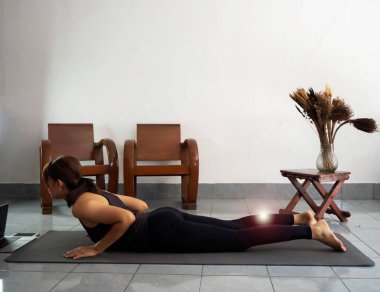 Kadının vücudunun geriye doğru eğilmesi, evdeki yoga minderinde strinklemesi, lenslerin yanma etkisi.