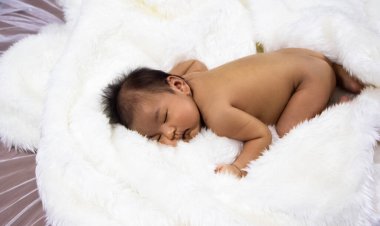 Yeni doğmuş bebek uyur yumuşak beyaz sikl kadife, bulanık ışık