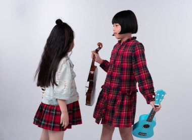 Ablam elinde keman ve ukulele tutuyordu. Küçük kız kardeşini sunmaya çalışıyordu..