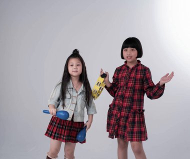 Ablam tef çalıyor, küçük kız kardeşim Maracas 'ı elinde tutuyor, birlikte hareket ediyor.