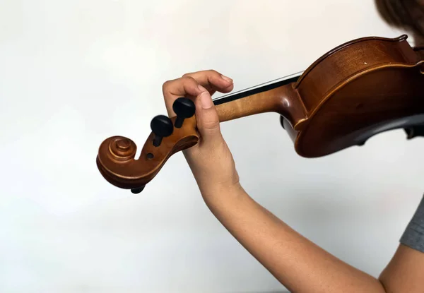 Human hand holding violin and put finger press on string,show how to play acoustic instrument