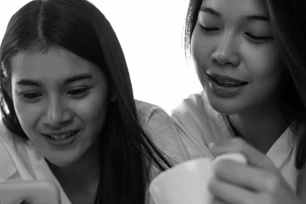 Face of two beautiful women talking together,with smile and happy feeling,roommate,good friendship,black and white tone