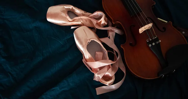 背景上放在小提琴旁边的芭蕾鞋对 — 图库照片