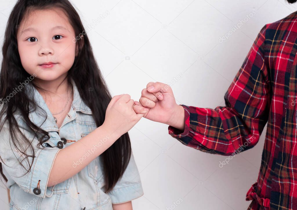Little girl doing Pinky Swear with her sister,with happy feeling