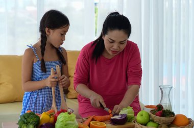 Anne kız salata yapıyorlar, evde mutlu vakit geçiriyorlar.