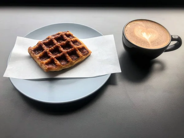 Waffle Filiżanka Kawy Stole Rozmyte Światło Wokół — Zdjęcie stockowe