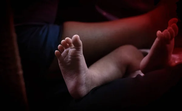 赤ちゃんの足の閉鎖 周りのぼやけた光 — ストック写真
