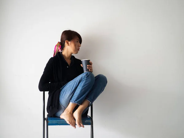 Vrouw Zit Stoel Tegen Muur Houdt Koffiebeker Hand Met Ongelukkig — Stockfoto