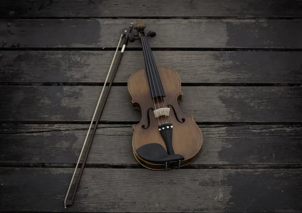 Violin and bow put on old wooden timber board,show detail of acoustic instrument