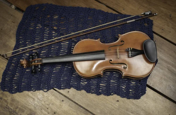Violin and bow put on wooden timber board,show detail of acoustic instrument