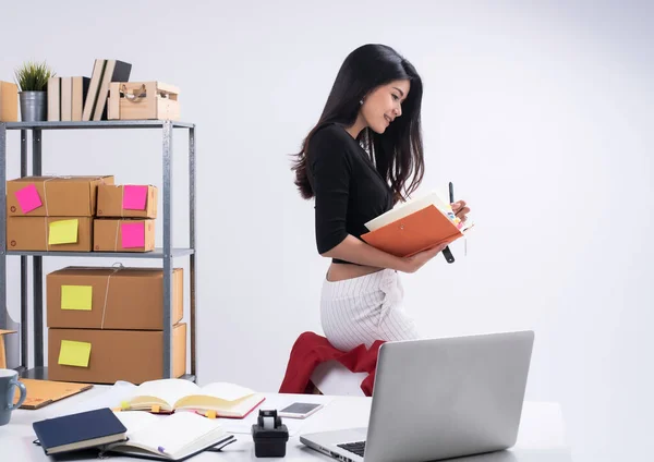 Beautiful lady checking order and writing on book,prepare for packing,working e-commerce,business woman