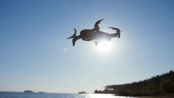 ヘリコプターは海の近くを飛び、写真やビデオを撮ります。ドローンカメラで飛行と撮影. — ストック動画