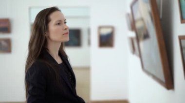 Close-up Zarif Güzel Kadın Modern Sanat Müzesi'nde Resimler bakar. Genç Kız Fotoğraf Galerisi'nde Fotoğraf İzliyor. Kent Sanat Galerisi'nde Sergide Sanat Eserleri. 