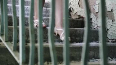 Kız merdivenlerden inip terk edilmiş bir binaya giriyor. Gettodaki yarı yıkılmış binalar. Neredeyse yıkılıyor ve şehir bloğunu mahvediyordu. Vandalizm modeli. Yıkım için eski bina. Gecekondu. Eski ev. 