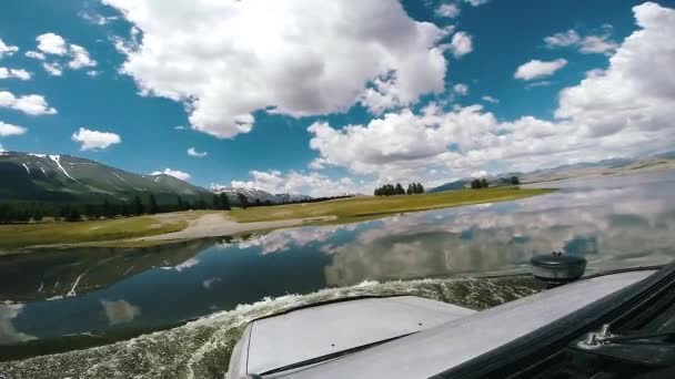 Auto cestování: SUV se pohybuje přes hluboký tok řeky. Jízda autem po horské silnici. POV - Pohled auta pohybující se podél krajiny. Terénní cestování. Koncept cestování automobilem. Stock Video