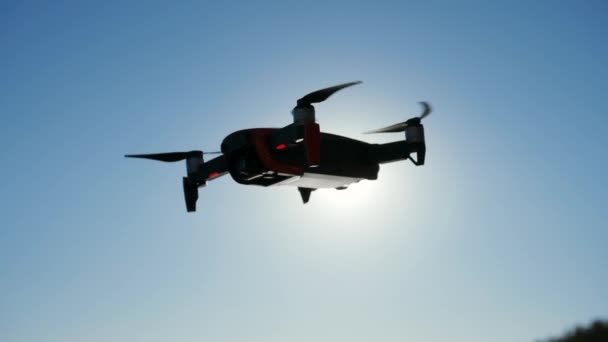 Flying and filming with drone camera. Copter flies near the sea, takes photos and videos. Copter close up. — Stock Video