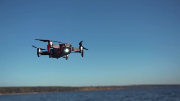 Repülés és forgatás drón kamerával. Négyes helikopter lebeg a levegőben, lassított felvétel. Repülő drón a tenger felett. — Stock videók