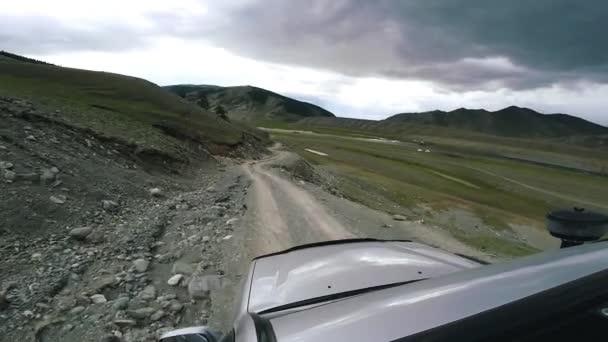 Car passing in high mountain road at summer. SUV rides a valley with mountains. Auto travel: POV - Point of view car moving along the countryside. Off road travel. Car traveling concept. — Stock video