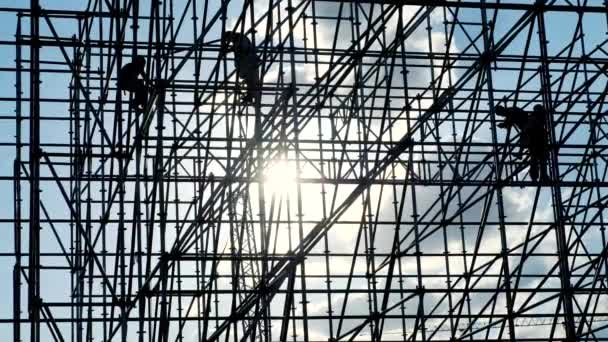 Silhouettes of male engineer worker at construction site. Workers at sunset builders assemble design. Concept building silhouette. Confident working technician. Construction equipment. — Stock Video