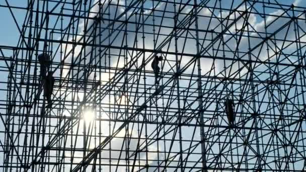 Siluetas del trabajador ingeniero masculino en la obra. Los trabajadores de los constructores del atardecer ensamblan el diseño. Silueta de construcción conceptual. Plan de trabajo de ingeniería. Color azul cielo. Fondo de contraste . — Vídeos de Stock